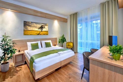 科瓦科瓦Hotel Kochau的酒店客房设有一张大床和一张书桌。