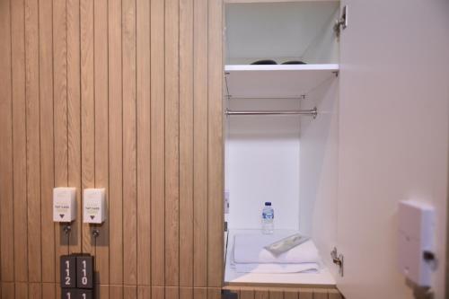 雅加达Whiz Capsule Hotel Thamrin Jakarta的木质墙壁的客房内设有带卫生间的浴室