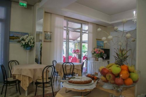 里米尼Hotel Brezza的用餐室配有带水果的桌子