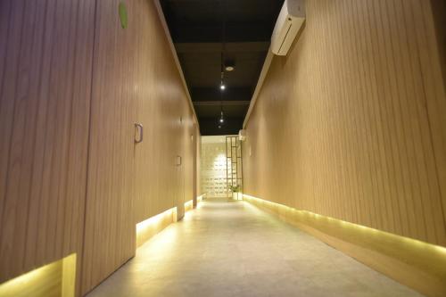 雅加达Whiz Capsule Hotel Thamrin Jakarta的走廊设有长长的走廊,设有木墙