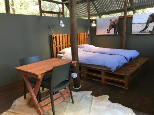 马翁Phazama Farm的一间卧室配有一张床、一张桌子和一张桌子
