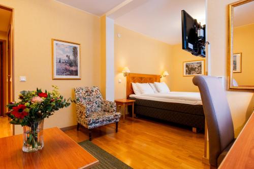 韦斯特罗斯Sure Hotel by Best Western Esplanade的配有床、椅子和桌子的酒店客房