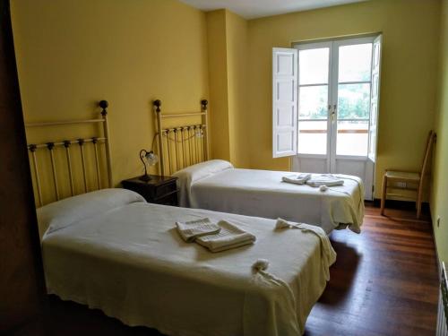SelayaPosada laventa的一间设有两张床铺和毛巾的房间