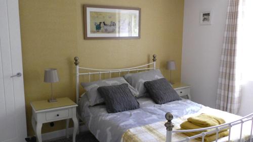 伊普斯威奇The Lodge Greatwood的一间卧室配有一张带2个床头柜和2盏灯的床。
