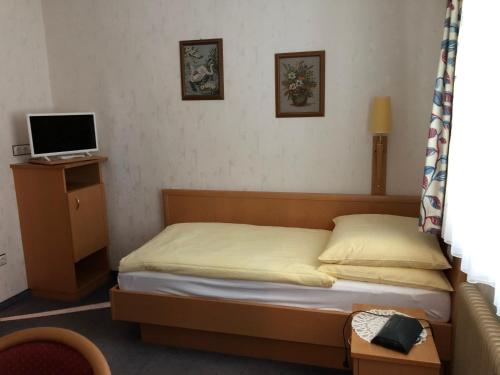 MariasdorfGasthof Koller的一间小卧室,配有一张床和电视