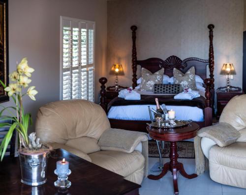 阿曼济姆托蒂Luxury Beach Apartments的一间卧室配有一张床、两把椅子和一张桌子