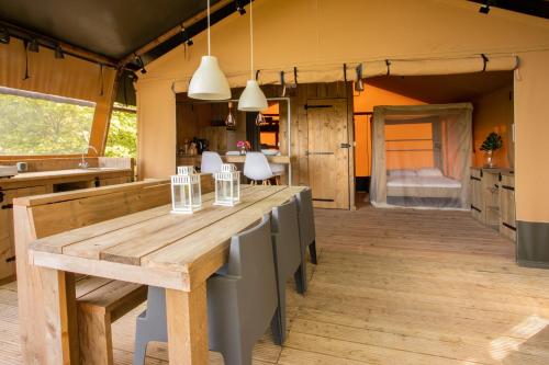 圣马力诺Lodge Holidays - Glamping San Marino的厨房配有大型木桌和椅子