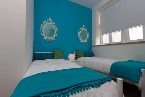 埃斯托利尔图里斯莫赛库洛旅馆的蓝色墙壁客房的两张床