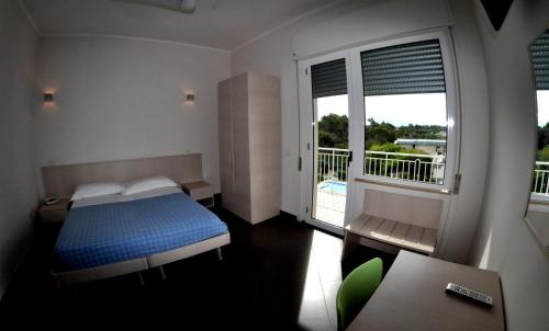 巴蒂帕利亚Albergo Riviera Spineta的一间卧室设有蓝色的床和一个阳台