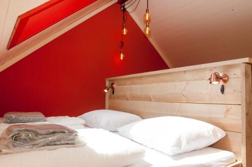 阿赫特克克Aan de Waterspiegel的红色墙壁的客房内的两张床