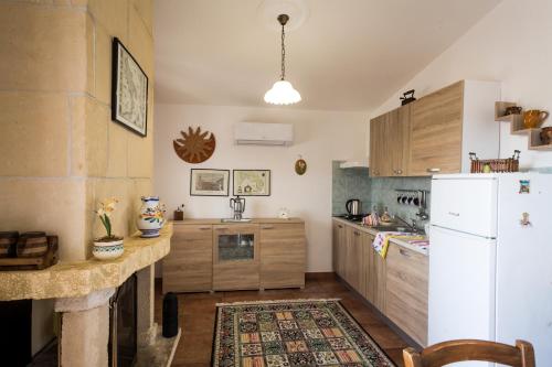 卡萨拉诺Le more Holiday Home的厨房配有白色冰箱和木制橱柜。