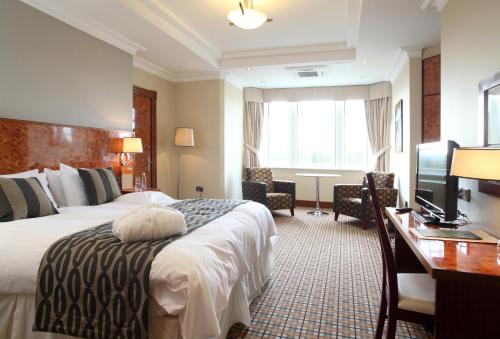 大雅茅斯码头酒店的酒店客房配有一张床、一张书桌和一台电视。