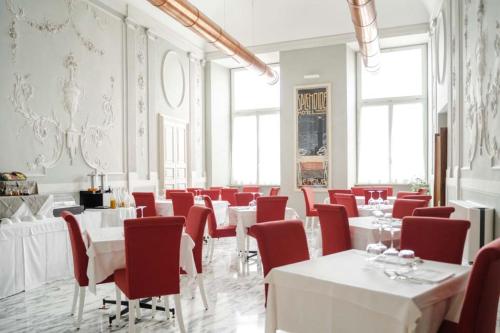 热那亚Hotel De Ville的用餐室配有白色的桌子和红色的椅子
