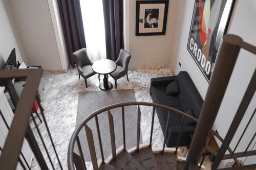 热那亚Hotel De Ville的一间带桌椅的客厅和楼梯