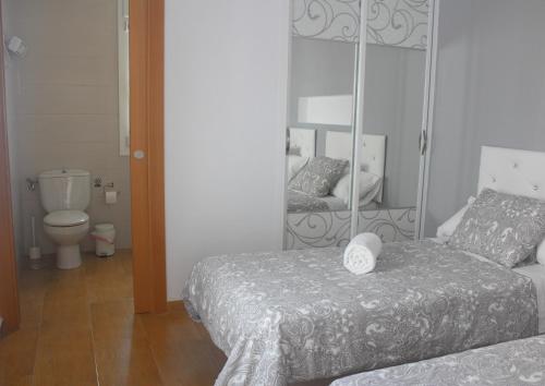 阿尔戈多纳莱斯Be happy Arco的一间卧室配有两张床和镜子