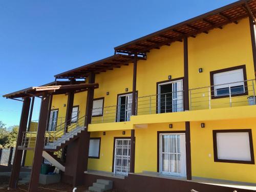 戈亚斯州上帕莱索Vila dos Cristais的黄色的建筑,旁边设有楼梯