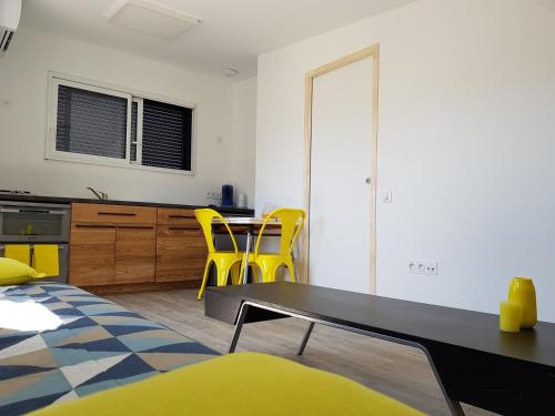 昂热Angers Green Lodge - Yellow Sun Appartement的客厅配有桌子和黄色椅子