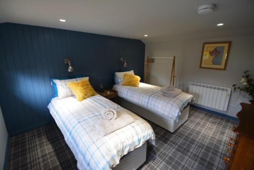 爱丁堡Craiglockhart Lodge的一间卧室配有两张带黄色枕头的床