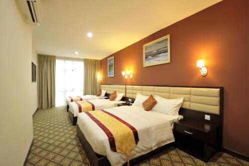 新山Hallmark Regency Hotel - Johor Bahru的一间酒店客房,房间内设有两张床