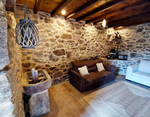 索尔波Apartamentos Casa do Bouza Vello的带沙发和石墙的客厅