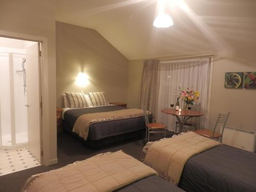 瓦纳卡瓦纳卡湖旅馆的酒店客房设有两张床和一张桌子。