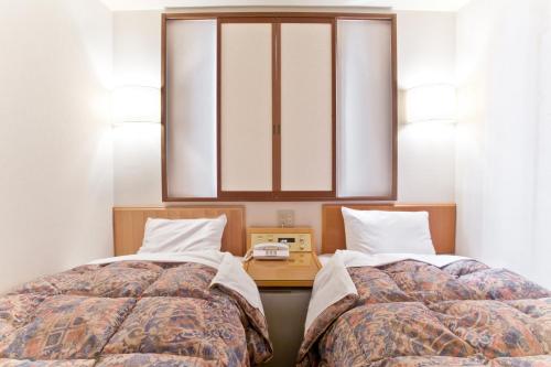 滨松滨松西库里塔克酒店的卧室内两张并排的床
