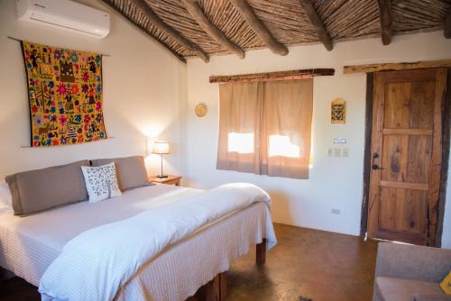阿拉莫斯El Pedregal - Hotel en la Naturaleza的卧室配有白色的床和窗户。