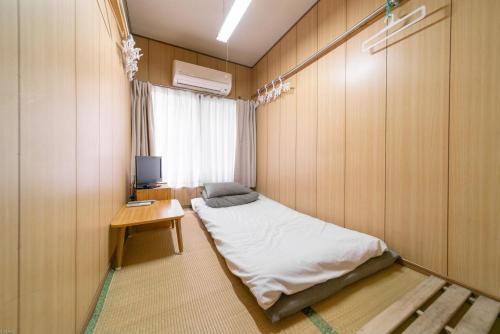 东京纳卡大雅旅馆的小房间设有一张床和一张书桌及电视