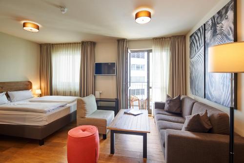 柏林柏林查理边境检查站蒙德里安套房酒店的酒店客房,配有床和沙发