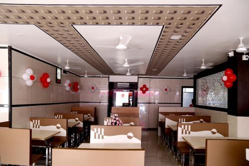 NavsāriHotel Shahi Darbar的一间带桌椅和红色气球的餐厅