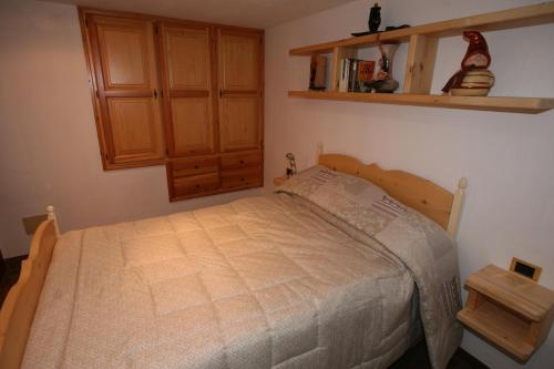 奥斯塔SUITE DEL VILLAGGIO的一间卧室配有一张床和一个木制橱柜