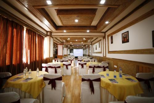 甘托克Yangthang Heritage的配有桌椅和黄色及白色桌布的房间