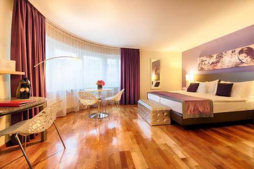 苏黎世苏黎世雷奥纳多精品酒店的酒店客房配有一张床铺和一张桌子。