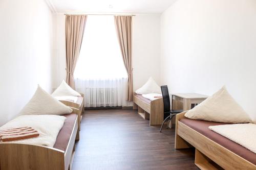 梅明根FMM Hostel的带三张床和窗户的客房