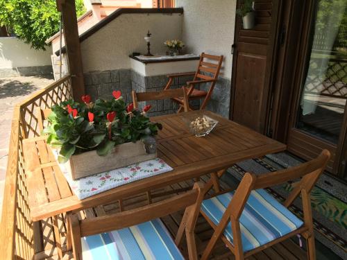 GiustinoLa CRI Bed & Breakfast的门廊上摆放着一张带椅子的木桌和盆栽植物