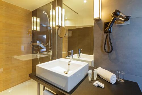洛桑法斯宾德瑞士葡萄酒酒店的浴室配有白色水槽和淋浴。