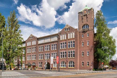 阿姆斯特丹Stayokay Hostel Amsterdam Oost的一座带钟楼的大型砖砌建筑