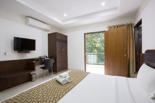 班加罗尔Sanctum Suites BEL Road Bangalore的一间卧室配有一张大床和毛巾
