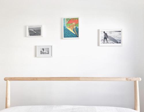 费雷尔Bay House Baleal - Surfboard included的卧室配有墙壁上的白色墙壁和图片