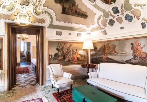 拉古萨Baroni Giampiccolo Suite的客厅墙上有绘画作品