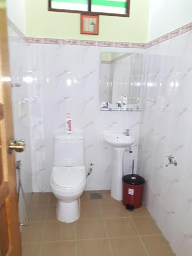 龙运Anjung Nor Muslim Homestay的白色的浴室设有卫生间和水槽。
