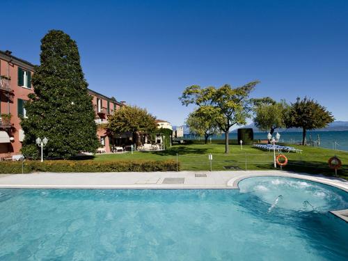 西尔米奥奈芳提波伊欧拉酒店的一个大型的游泳池,背景是大海
