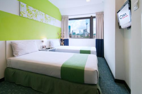 吉隆坡康帕斯酒店集团思庭老清真寺酒店的一间酒店客房,设有两张床和电视