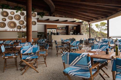 伊斯基亚Mezzatorre Hotel & Thermal Spa的餐厅设有木桌和蓝色椅子
