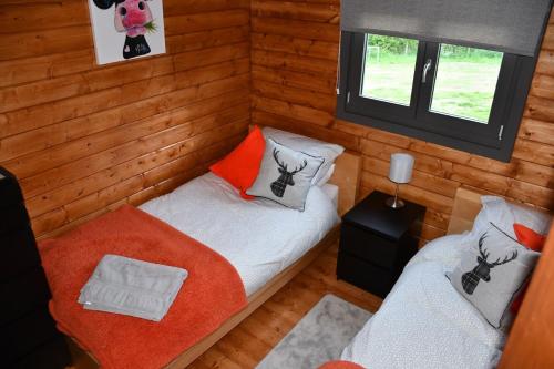 奈顿Long Wood Lodges的小房间设有两张床和窗户