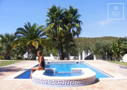 圣布拉什迪阿尔波特尔Quinta do Carmo的坐在游泳池旁的女人