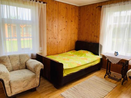TreimaniTreimani Country House的卧室配有床、椅子和窗户。