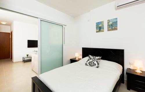 巴特亚姆巴特亚姆旅游4号公寓的卧室配有白色的床和玻璃墙