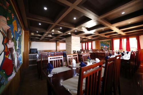 拉瓦格拉Buddha Retreat的一间带长桌和椅子的用餐室
