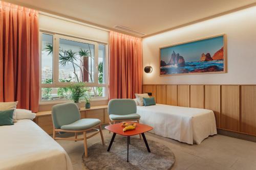 阿德耶罗卡娜微瑞雅阿德里安酒店的酒店客房带两张床和一张桌子以及椅子。